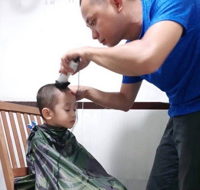 Sau khi cắt tóc cho mình (với sự hỗ trợ của vợ), anh Tiến Minh “ủi” cho các con  /// Ảnh: NVCC